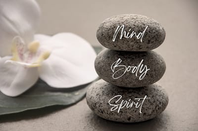 Stacked stones with text 'Mind, Body, Spirit'.