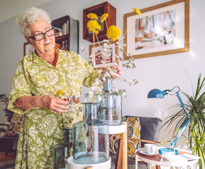 Resident arranging flowers in a cozy common area.