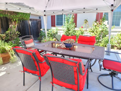 Outdoor dining area with red chairs and a table.