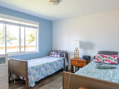 Shared resident room with two beds and natural light.