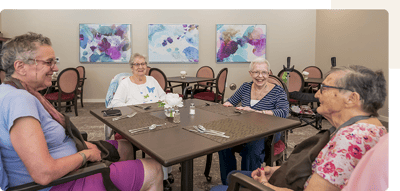 Seniors enjoying a meal together in the dining room.