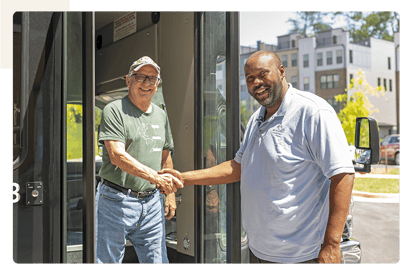 Residents and staff interacting outside a vehicle