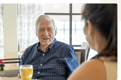 Senior man engaged in conversation with staff member.