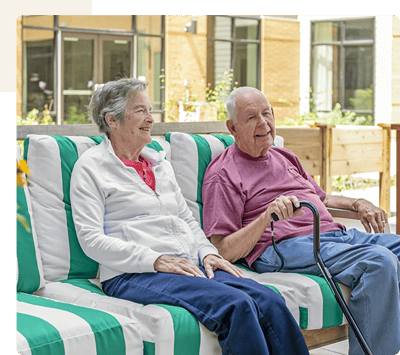 Two residents enjoying time outdoors on couches.