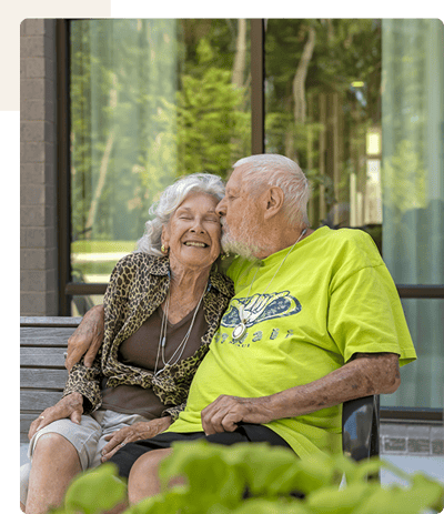 Elderly couple sharing a joyful moment outdoors.