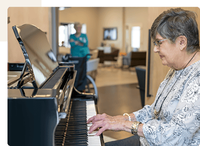 Resident playing piano in a common area.