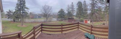 Scenic view from a wooden deck overlooking greenery.