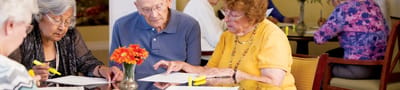 Residents engaged in an activity at a communal table.