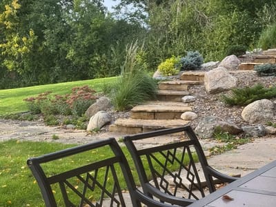 Landscaped outdoor space with stone steps and seating