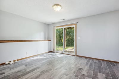 Bright, empty room with sliding door access to outdoors