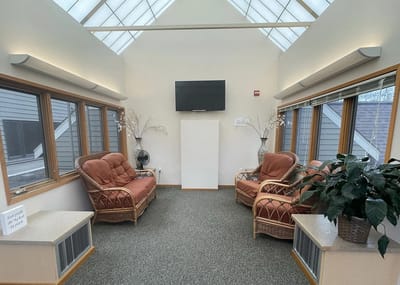 Bright common area with seating and large windows