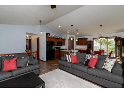 Comfortable living room space with sofas and a kitchen area