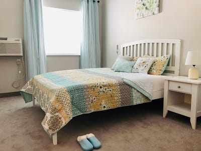 A cozy bedroom with a colorful quilt and soft decor