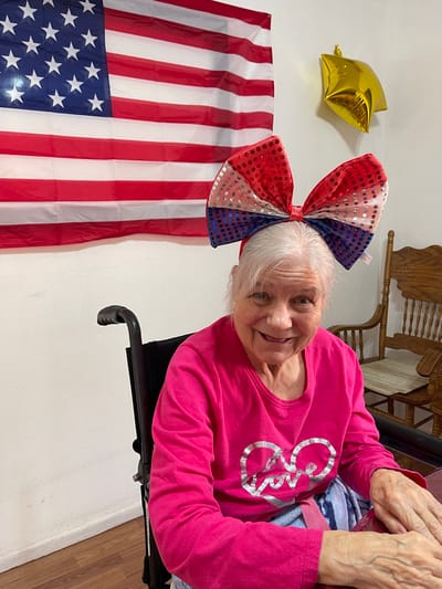 Resident with a large bow in a decorated room