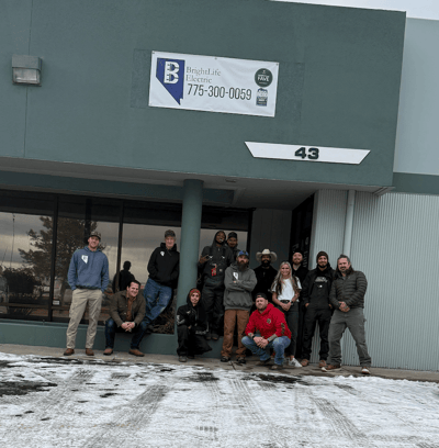 Group photo of staff outside the facility entrance