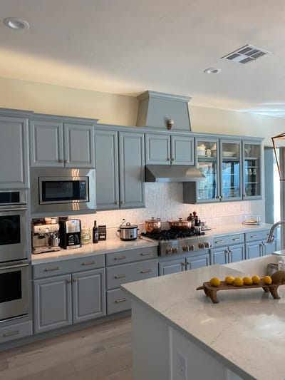 Modern kitchen area with gray cabinets and appliances