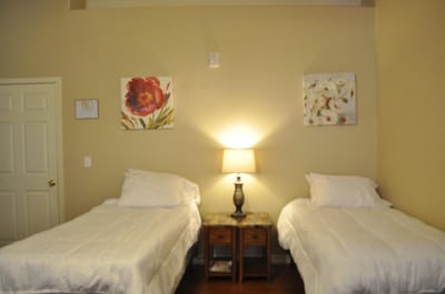 A cozy shared resident room with two beds and artwork