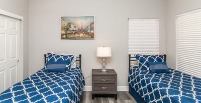 Brightly lit resident room with twin beds and a painting