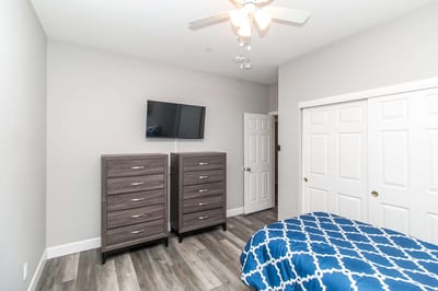 Bright private resident room with dresser and bed