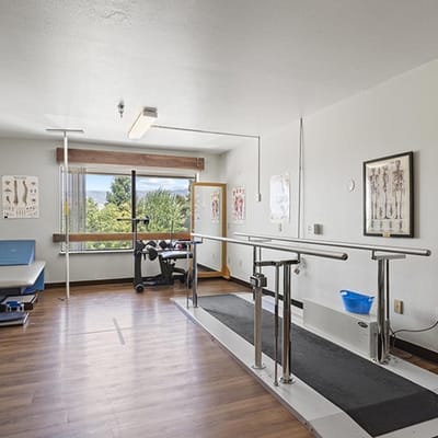 Interior therapy room with parallel bars and large window