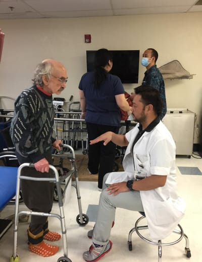 Medical staff assisting a resident in a care facility