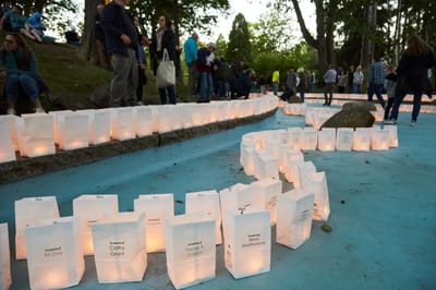 People gathered around illuminated lanterns at an event.