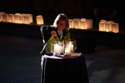 Person lighting candles at a ceremony.
