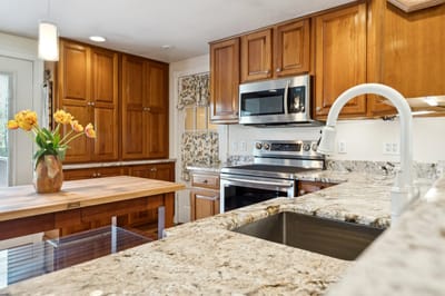 Modern kitchen with wooden cabinets and granite countertops.