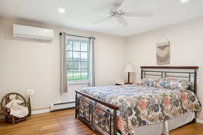 Cozy bedroom with floral bedspread and natural light.