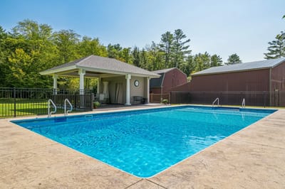 Outdoor swimming pool area with surrounding trees