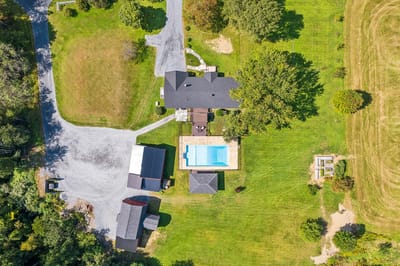 Aerial view of a facility with a pool and green space.