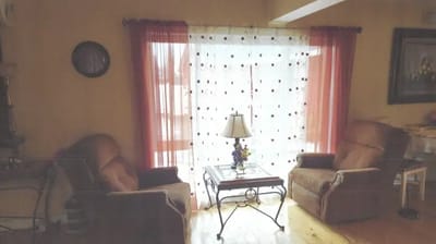 Cozy living room setup with chairs and lamp.