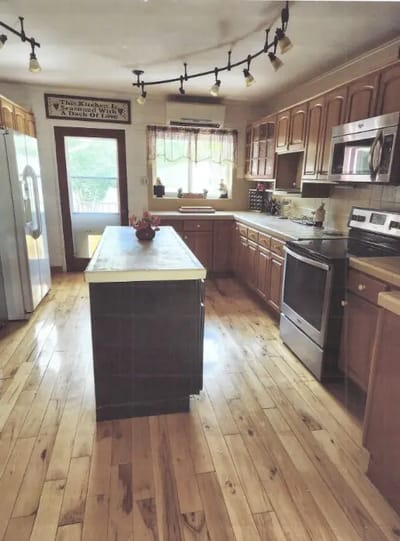 Bright kitchen area with wooden floors and appliances.