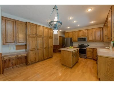 Large kitchen with wooden cabinets and appliances