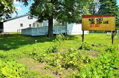 Exterior view of Windy Acres Long Term Care facility with sign