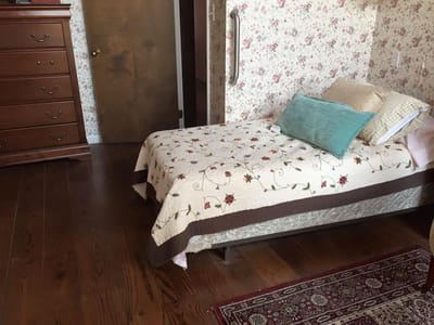 Cozy bedroom with floral wallpaper and wood furniture