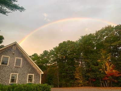 Building exterior under a rainbow with trees