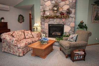 Cozy sitting area with a stone fireplace and floral couches