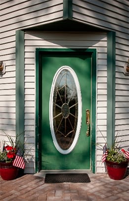 Americare Lodges, assisted living in Grand Rapids, MN — Green front door with decorative window and planted flowers