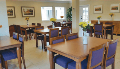Bright common area with tables and flowers