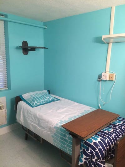 Private resident room with turquoise walls and bed