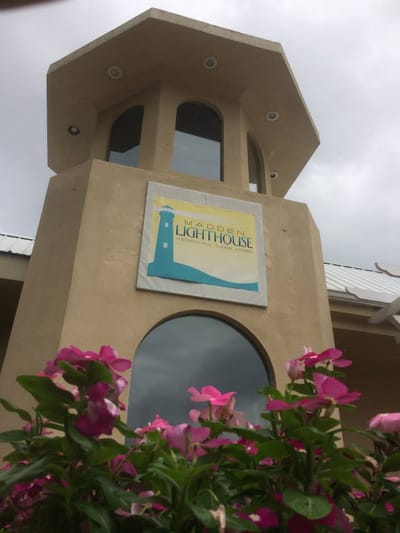 Exterior view of Madden Lighthouse with floral accents