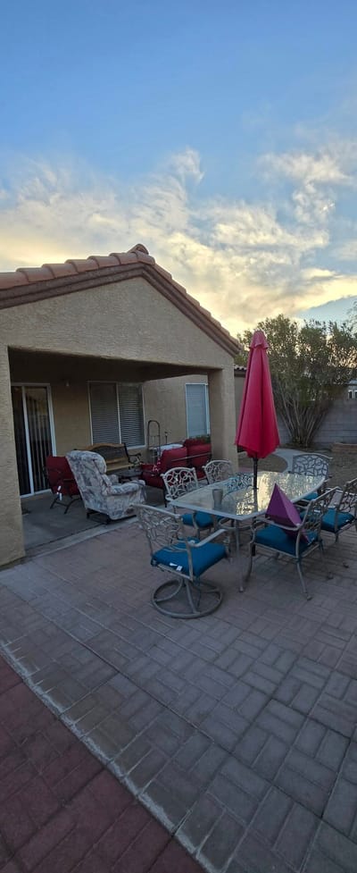 Outdoor seating area with patio furniture and a red umbrella