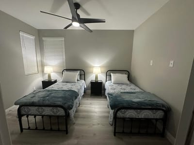 A cozy shared bedroom with two beds and lamps