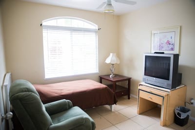 Bright private room with a bed and TV