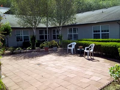 Outdoor patio area with chairs and landscaped surroundings