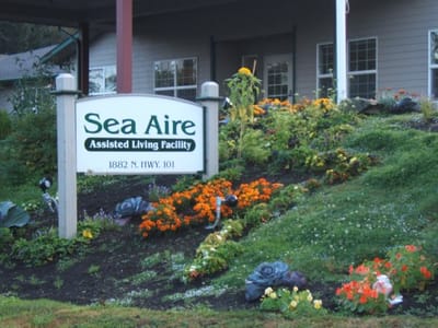 Exterior sign of Sea Aire Assisted Living Facility with flowers