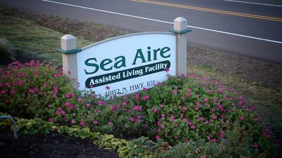 Sign for Sea Aire Assisted Living Facility surrounded by flowers
