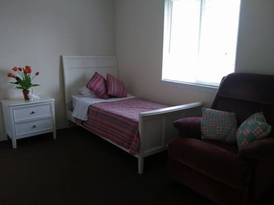 Cozy resident bedroom with a bed and chair