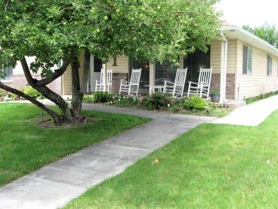 Exterior view of a senior living facility with rocking chairs